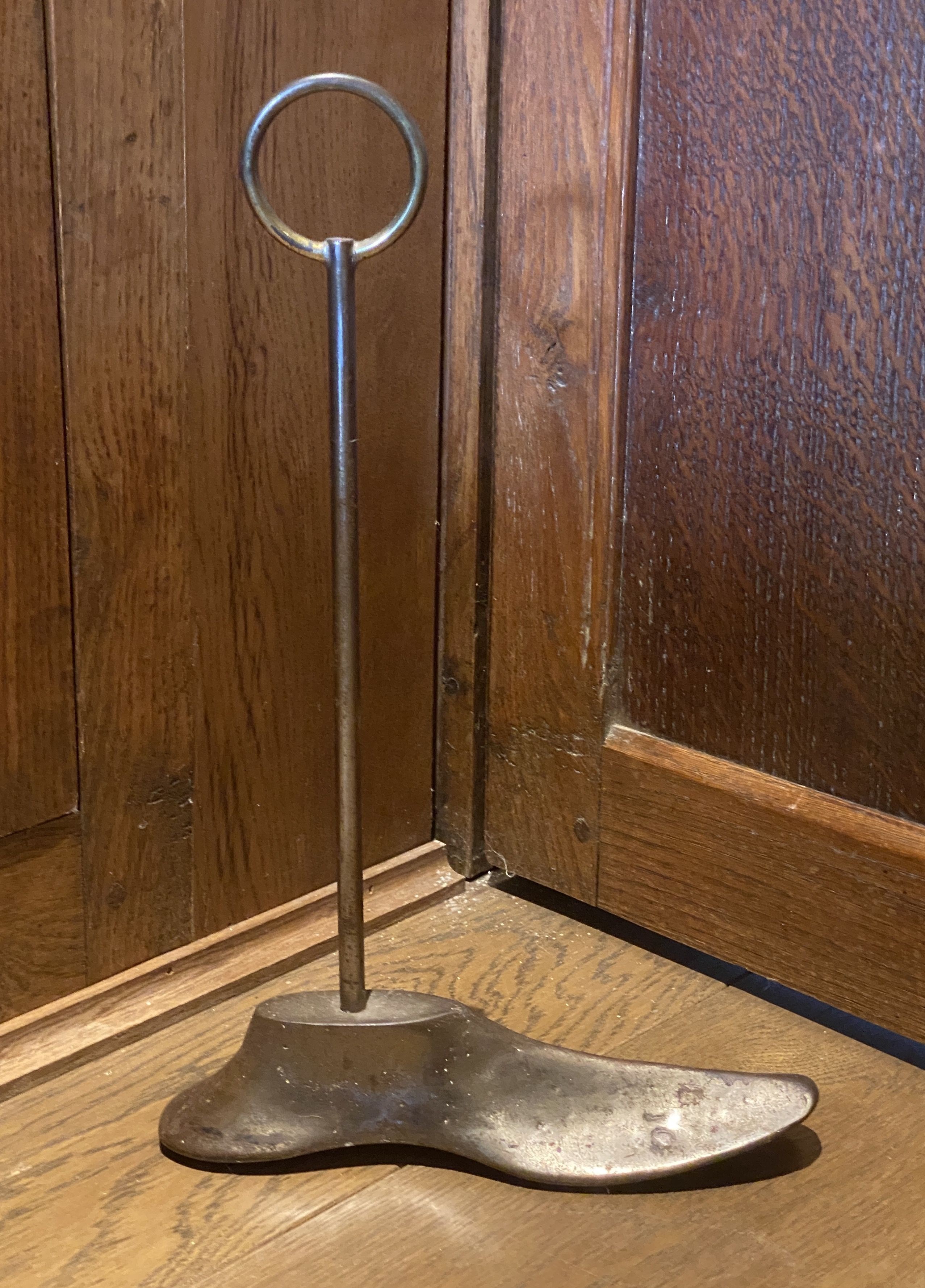 A door porter made from brass and steel with a shoemaker's last, height 39cm